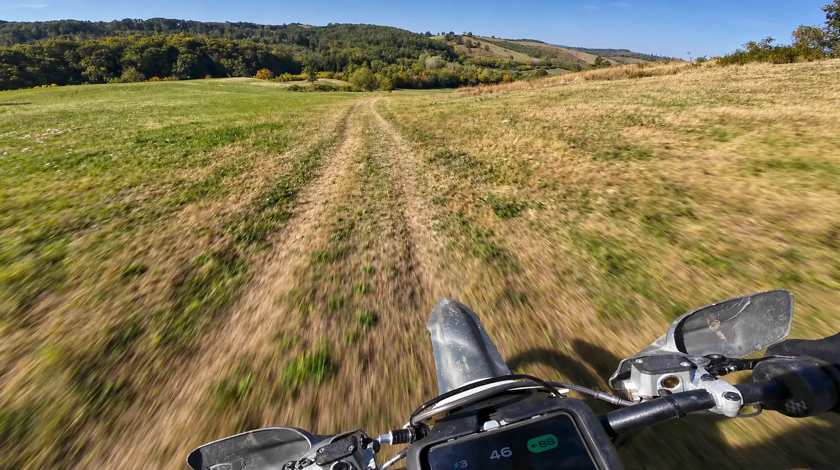 Enduro-Fahrt aus der Fahrerperspektive durch eine Sommerwiese in Pannonien